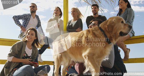 Image of Group of friends having fun on autumn day at beach