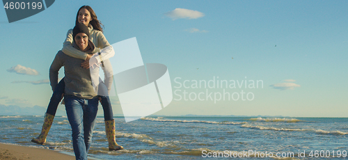 Image of couple having fun at beach during autumn