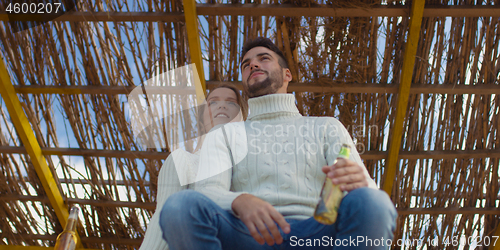 Image of Couple drinking beer together at the beach