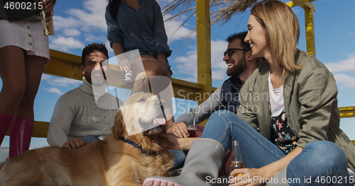 Image of Group of friends having fun on autumn day at beach