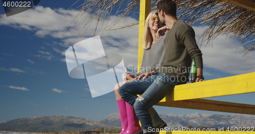 Image of Couple drinking beer together at the beach