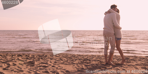 Image of Loving young couple on a beach at autumn on sunny day