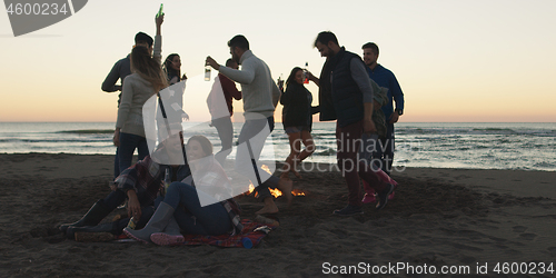 Image of Friends having fun at beach on autumn day