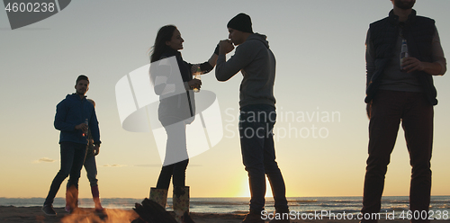 Image of Friends having fun at beach on autumn day