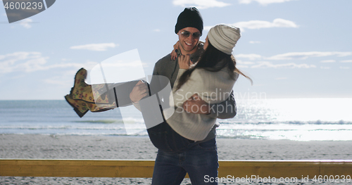 Image of Couple having fun on beautiful autumn day at beach