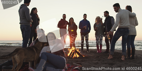 Image of Friends having fun at beach on autumn day