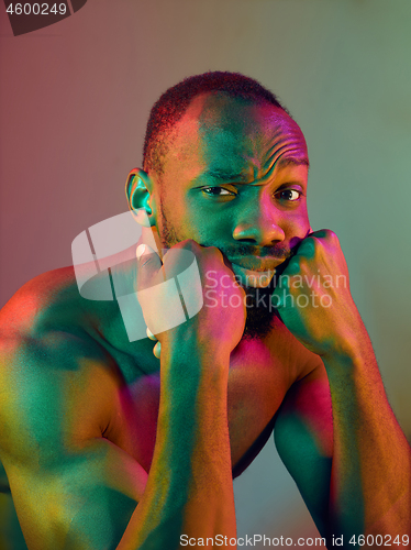 Image of Close up portrait of a young naked african man looking at camera indoors