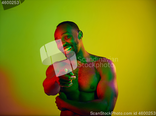 Image of Close up portrait of a young naked african man looking at camera indoors