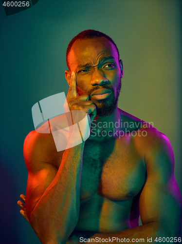 Image of Close up portrait of a young naked african man looking at camera indoors