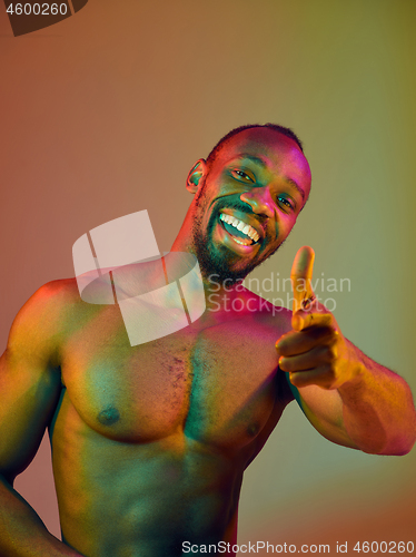 Image of Close up portrait of a young naked african man looking at camera indoors