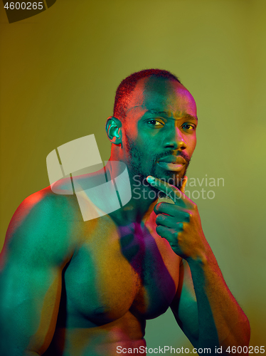 Image of Close up portrait of a young naked african man looking at camera indoors