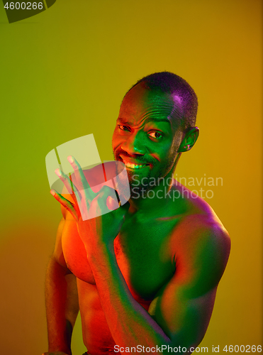 Image of Close up portrait of a young naked african man looking at camera indoors