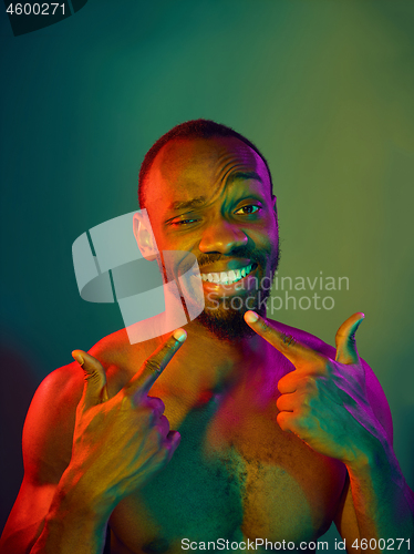 Image of Close up portrait of a young naked african man looking at camera indoors