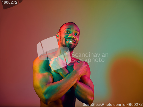 Image of Close up portrait of a young naked african man looking at camera indoors