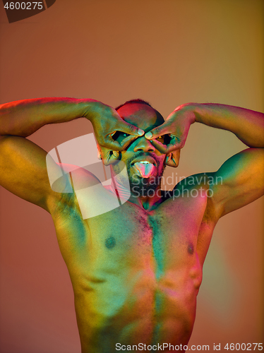 Image of Close up portrait of a young naked african man looking at camera indoors