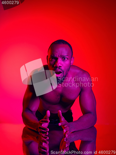 Image of Close up portrait of a young naked african man looking at camera indoors