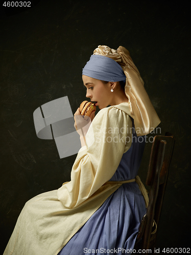 Image of Medieval Woman in Historical Costume Wearing Corset Dress and Bonnet.