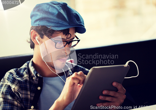 Image of close up of man with tablet pc and earphones