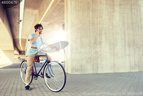 Image of man with smartphone and fixed gear bike on street