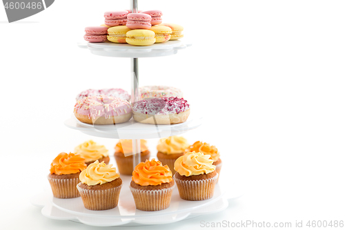 Image of glazed donuts, cupcakes and macarons on stand