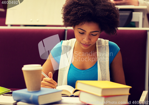 Image of student girl with books and coffee on lecture