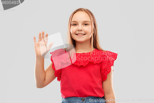 Image of beautiful smiling girl in red shirt waving hand