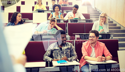 Image of group of students with notebooks at lecture hall