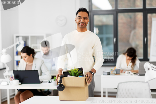 Image of happy male office worker with personal stuff