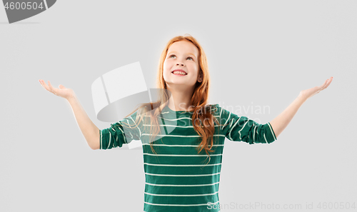 Image of happy grateful red haired girl looking up above