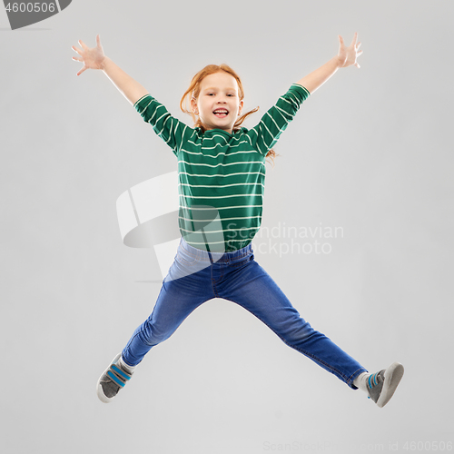 Image of smiling red haired girl in striped shirt jumping