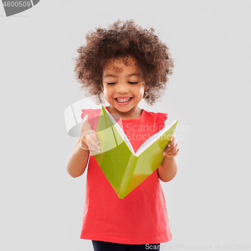 Image of happy little african american girl reading book