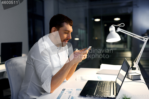 Image of businessman with smartphone and computer at office