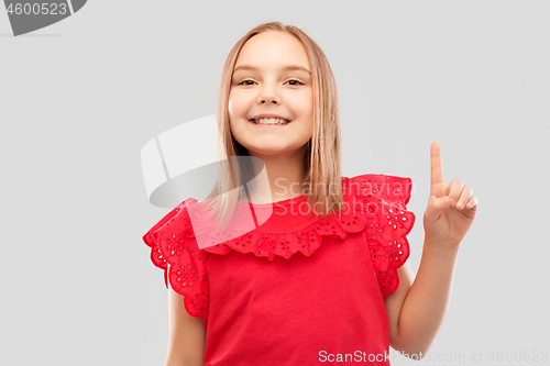 Image of smiling girl in red shirt pointing finger up
