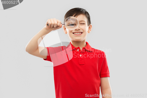 Image of smiling boy looking through magnifying glass