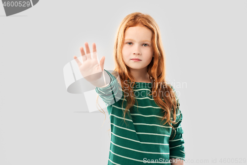 Image of red haired girl showing stop gesture