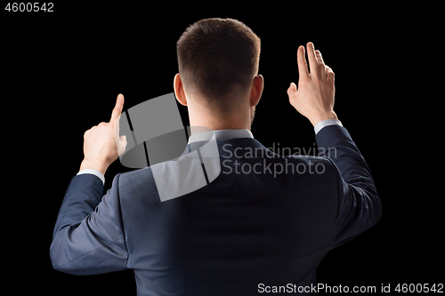 Image of businessman working with invisible virtual screen