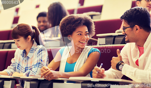 Image of group of students with notebooks in lecture hall