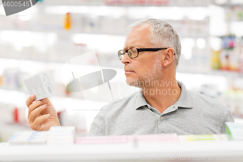 Image of senior male customer with drug at pharmacy