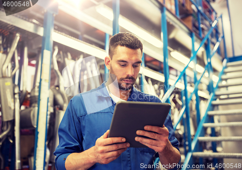 Image of auto mechanic or smith with tablet pc at workshop