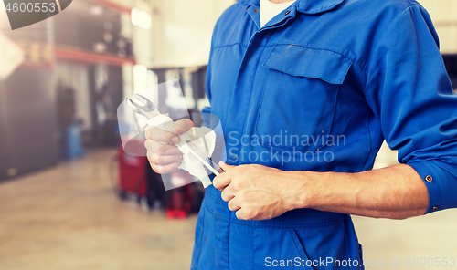 Image of auto mechanic or smith with wrench at car workshop