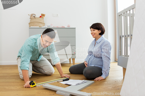 Image of family couple assembling baby bed at home