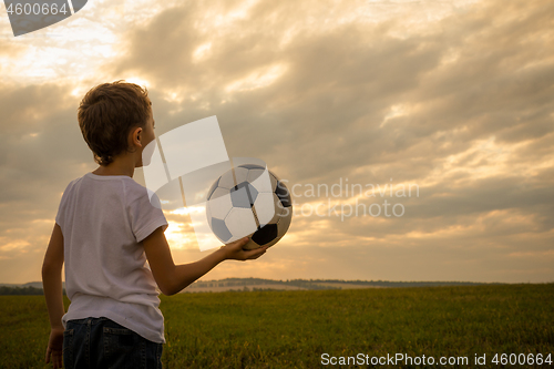 Image of Portrait of a young  boy with soccer ball.