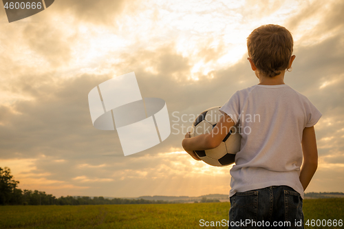 Image of Portrait of a young  boy with soccer ball.