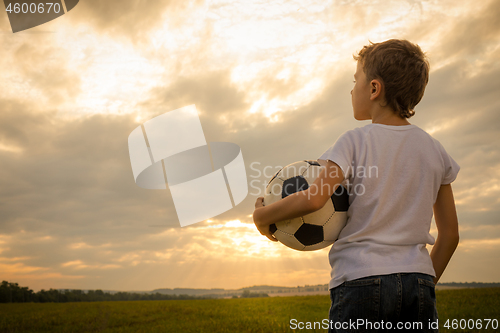 Image of Portrait of a young  boy with soccer ball.