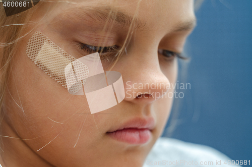 Image of On the girl\'s face is glued Band-Aid, close-up