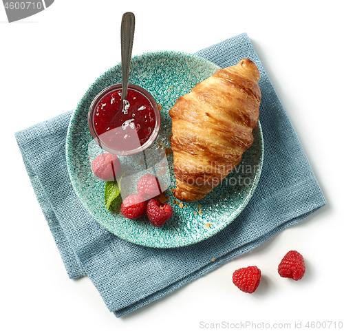 Image of freshly baked croissant on blue plate