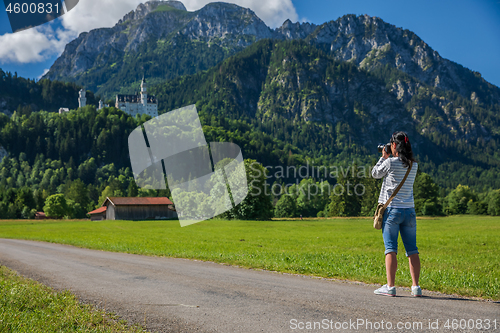 Image of Female tourist taking photos Neuschwanstein Castle Bavarian Alps