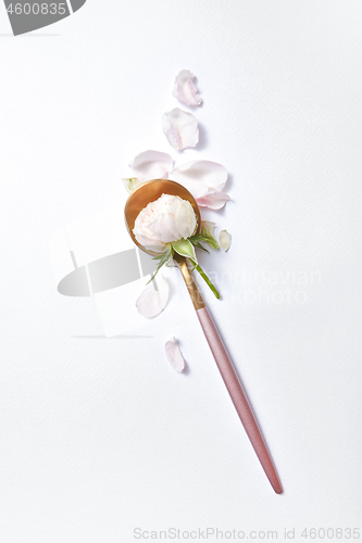 Image of Golden long spoon with rose flower.