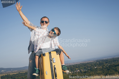 Image of Father and son standing on the road at the day time. 