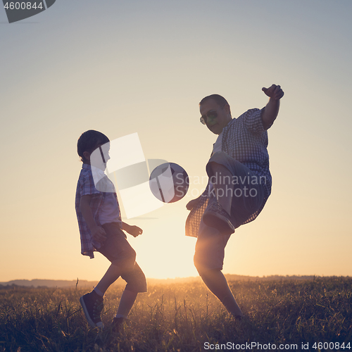 Image of Father and young little boy playing in the field  with soccer ba